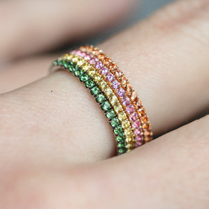 Green garnet ring in 18ct white gold on a hand stacked next to other eternity rings.