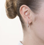 Diamond half set earrings in rose gold on a model's ear.
