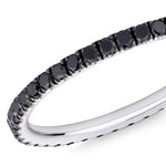 Closeup image of a black diamond eternity ring with 18 carat white gold on a white background