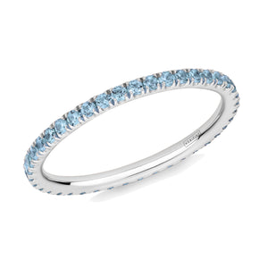 Blue Topaz eternity ring in platinum on a white background.